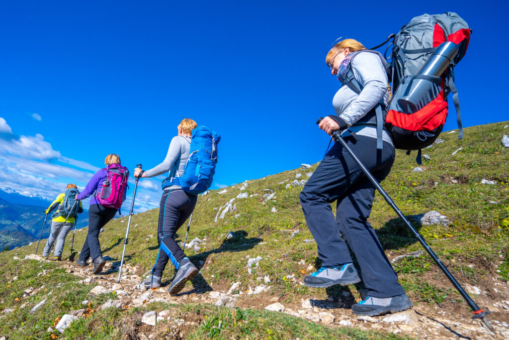 Women hiking in mountains, sunny day with clear blue sky
